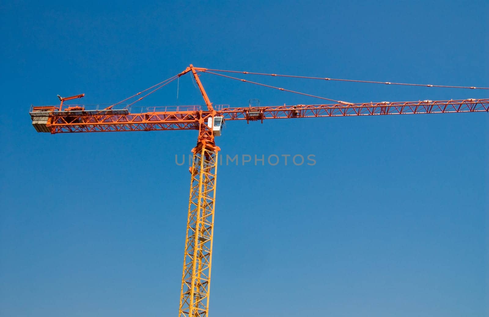 construction crane in orange on a blue sky