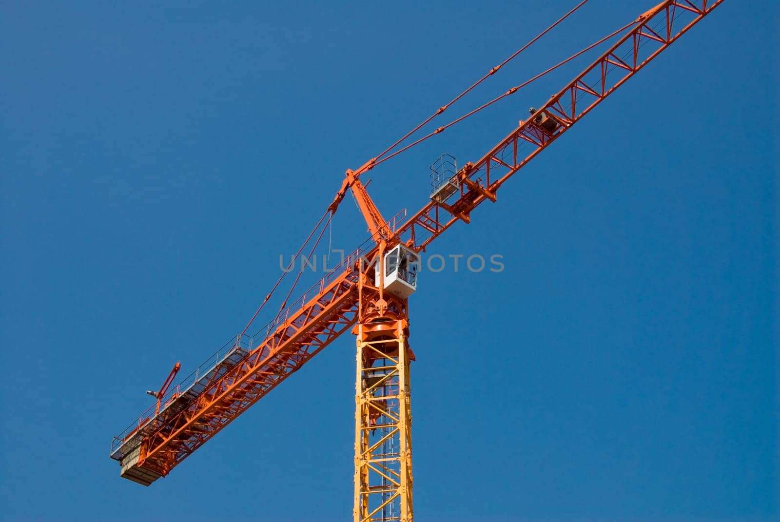 construction crane in orange on a blue sky