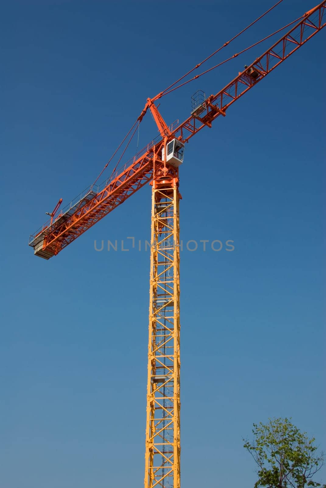 construction crane in orange on a blue sky
