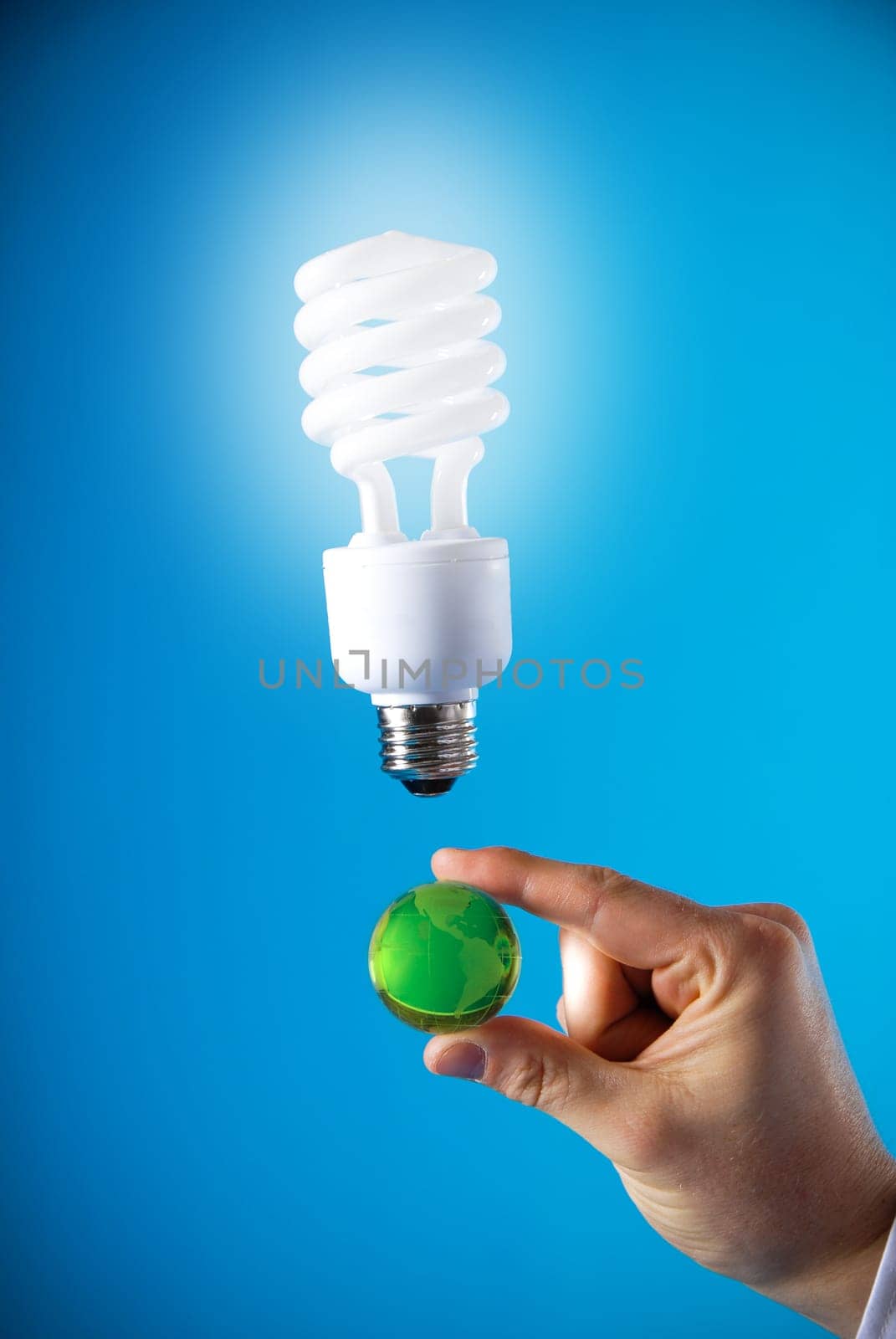 a hand with a floating light bulb and a planet