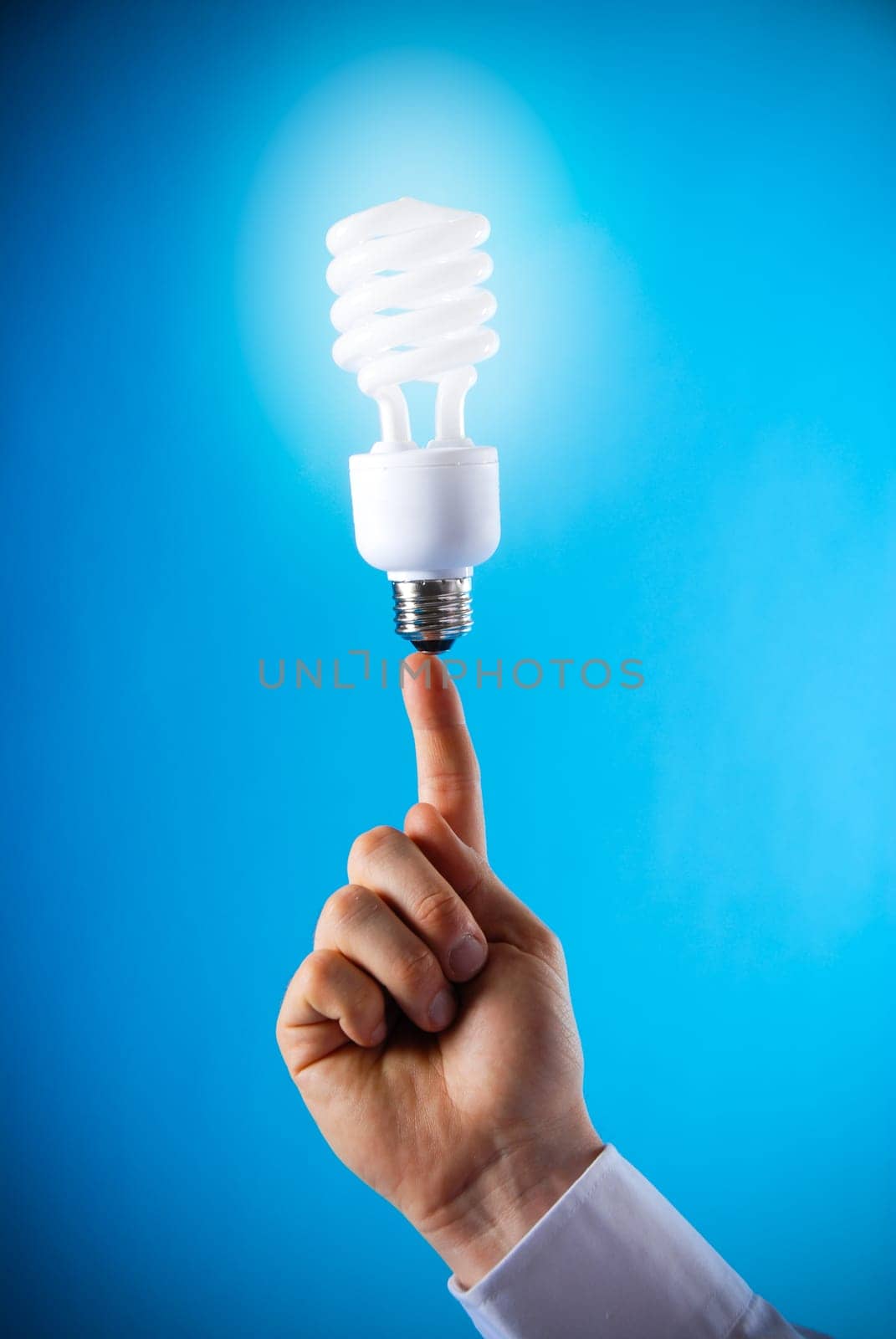 a hand with a floating light bulb on finger