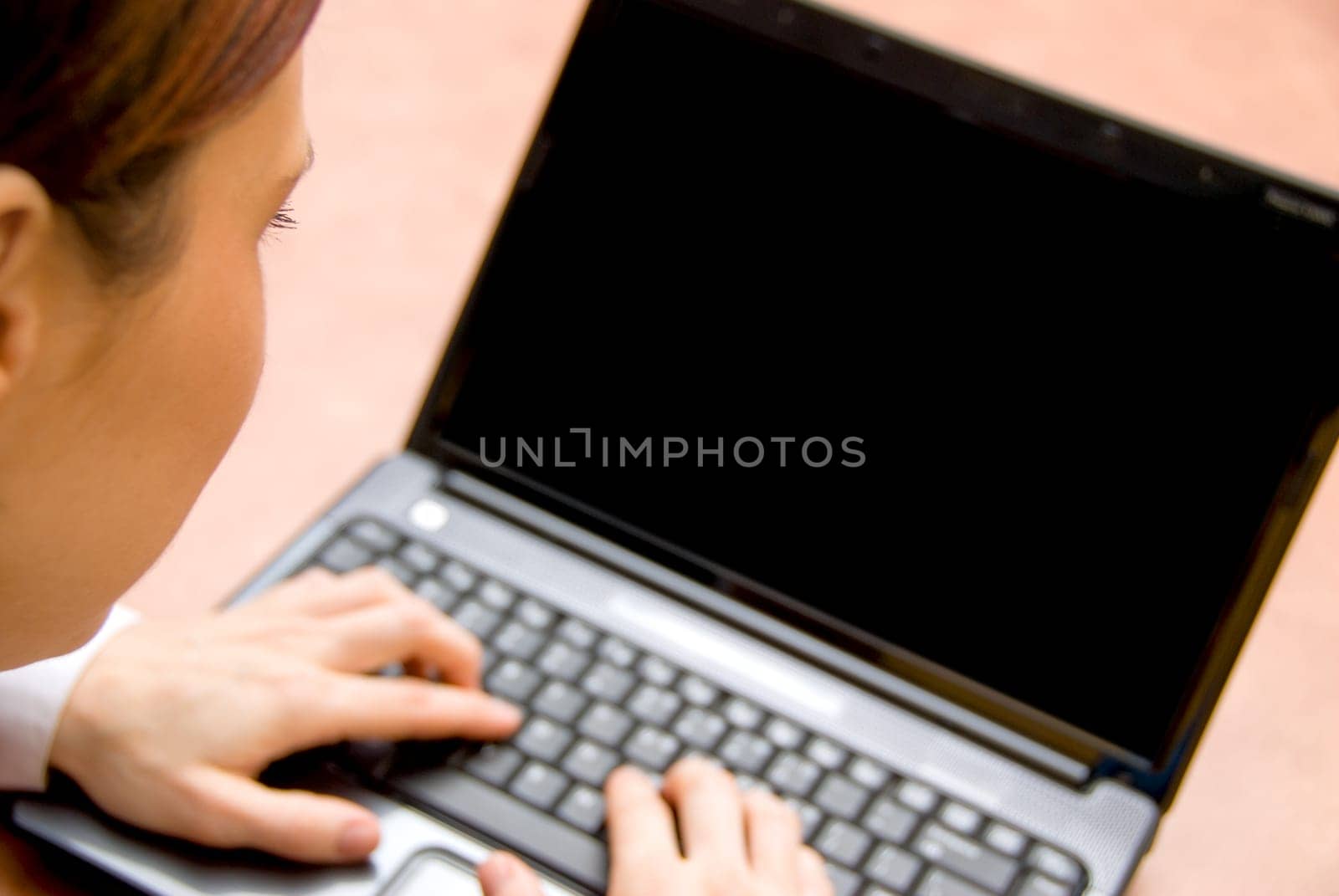 woman in a meeting typing on her laptop