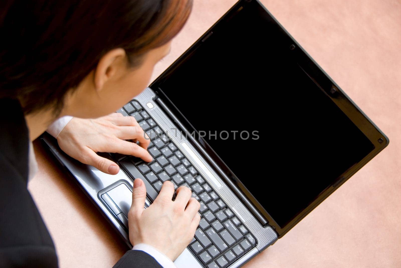 woman in a meeting typing on her laptop