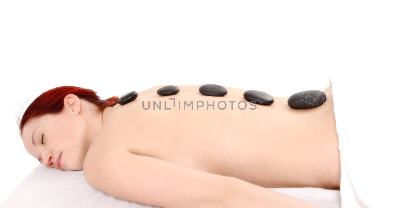 woman with red hair getting a stone massage