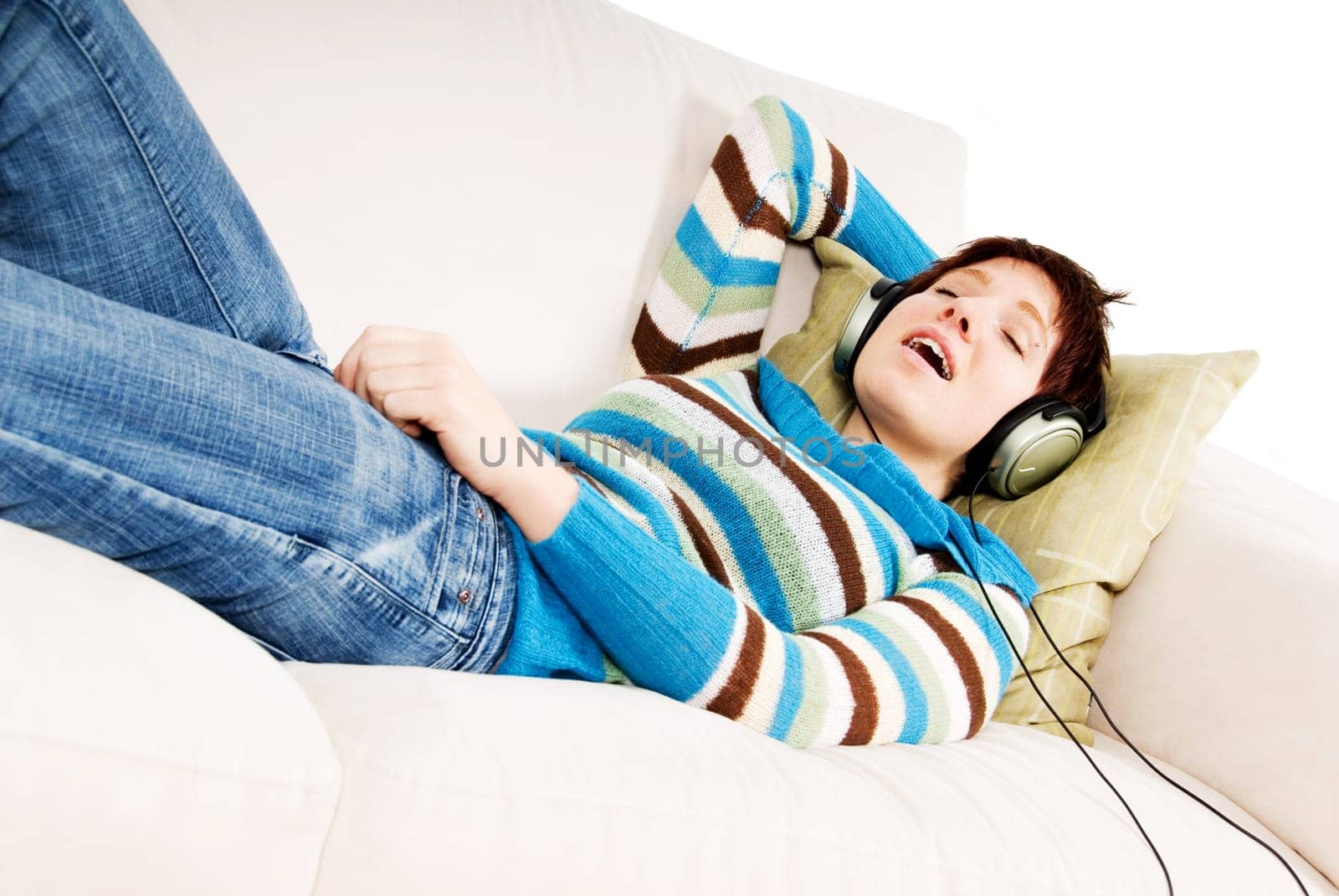 cute girl lying on the sofa listening to music