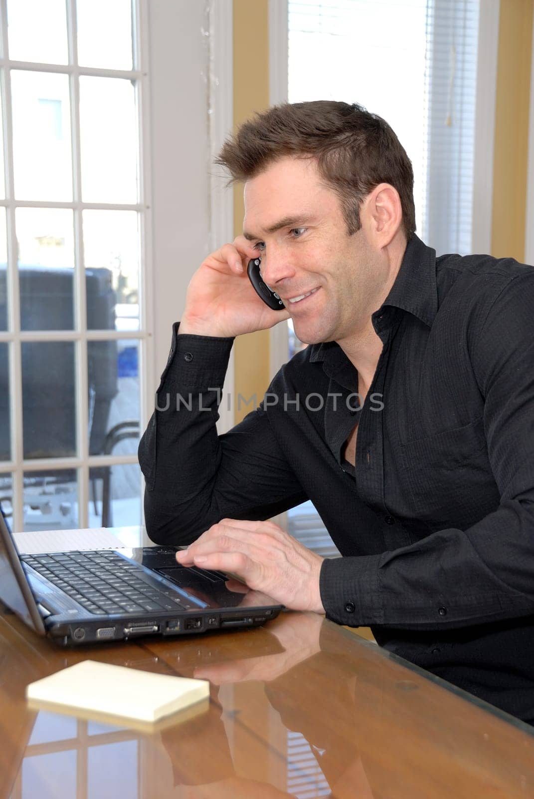 cute guy on the phone looking at his laptop