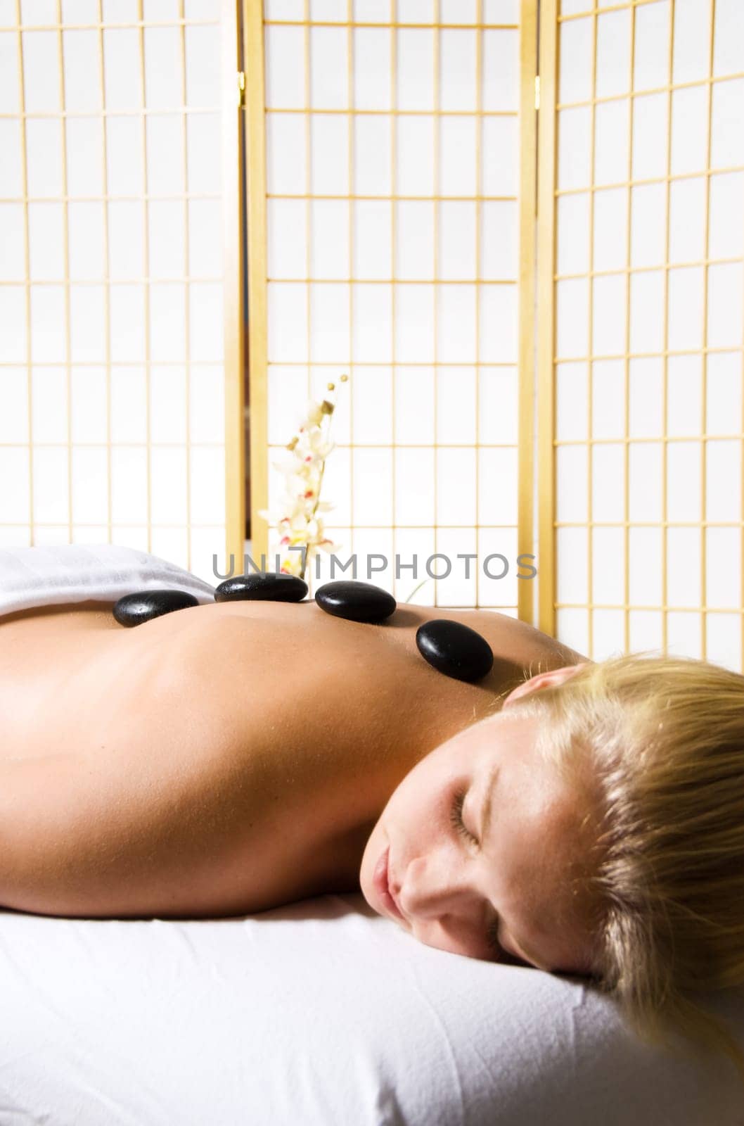 woman getting a hot stone massage at a day spa