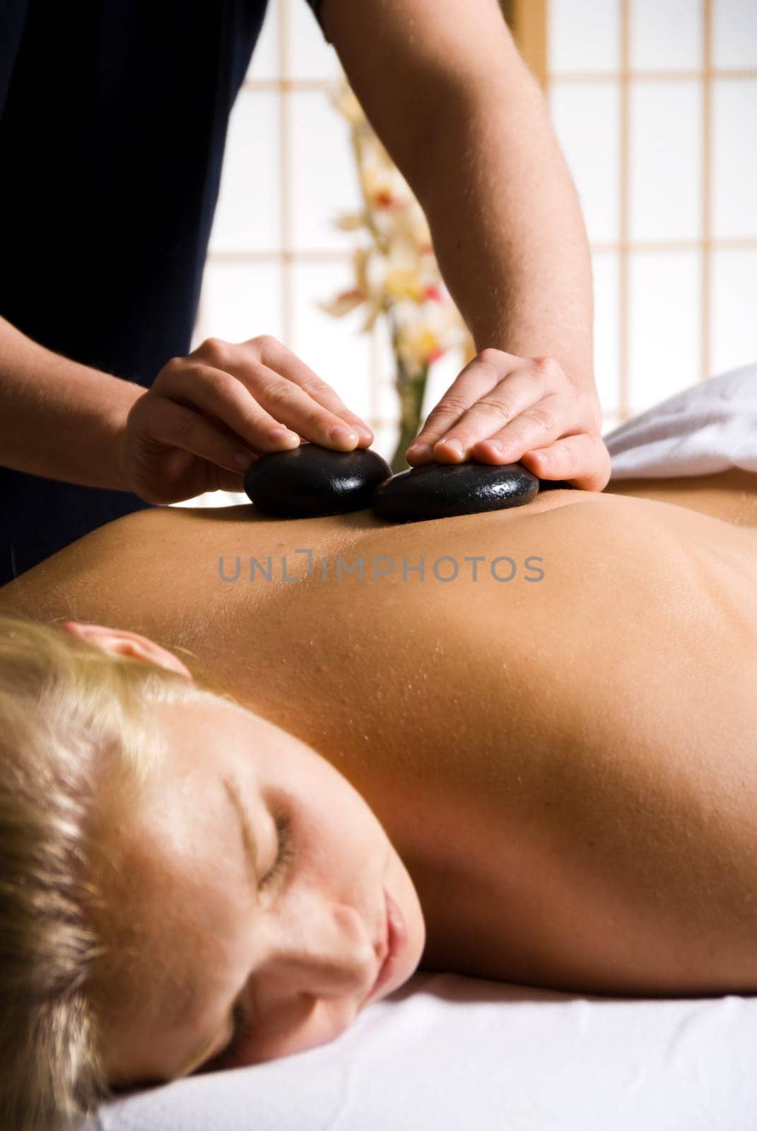 woman getting a hot stone massage at a day spa