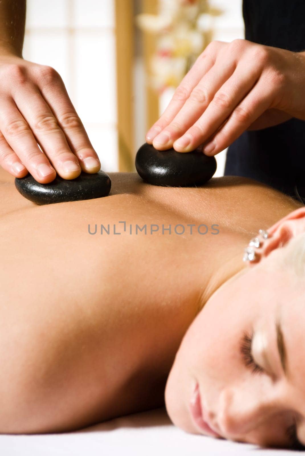 woman getting a hot stone massage at a day spa