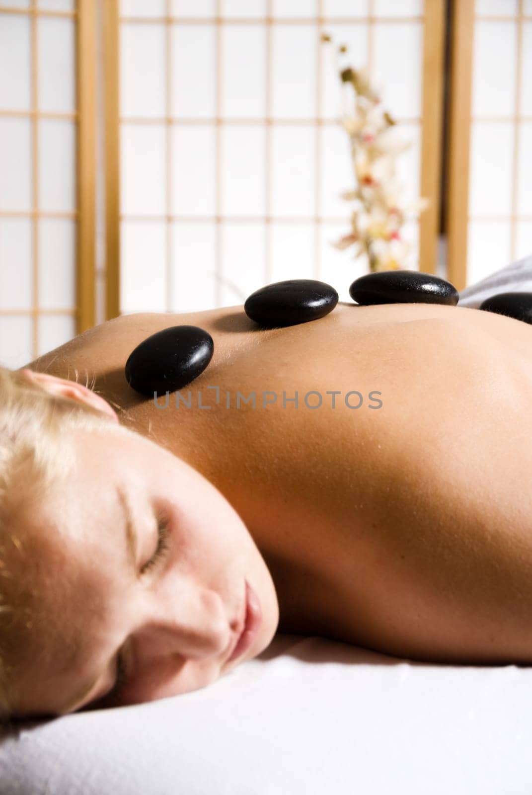 woman getting a hot stone massage at a day spa