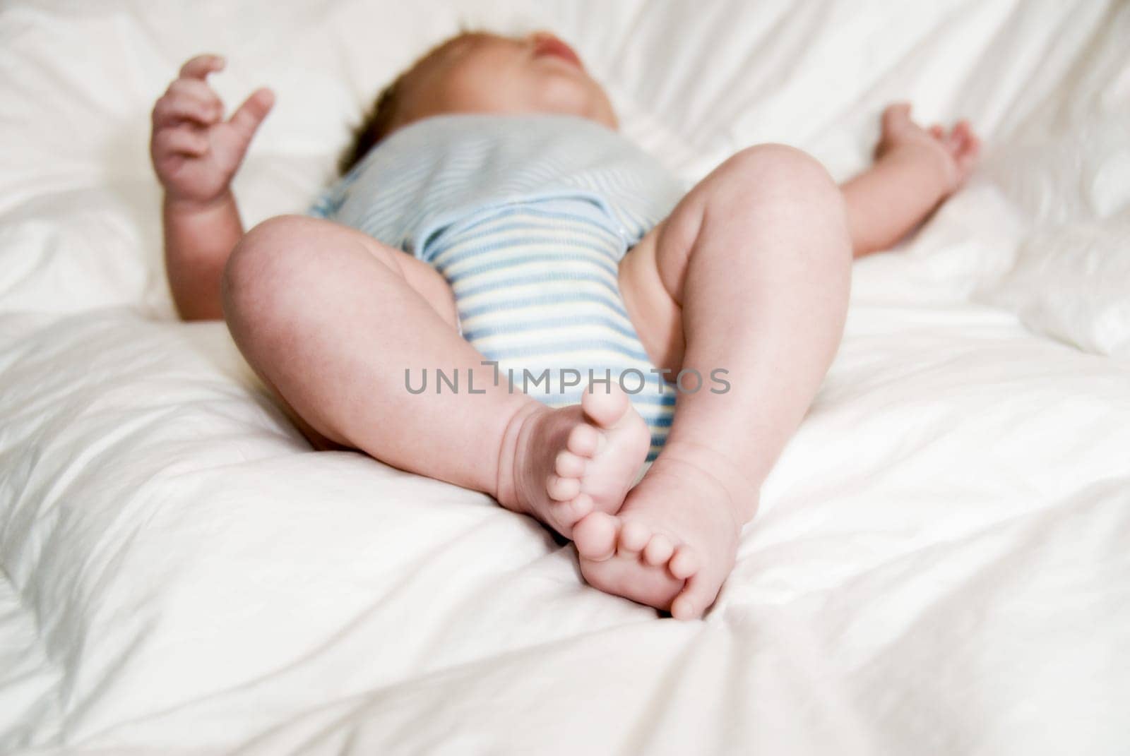 sleeping baby on a white blanket with feet