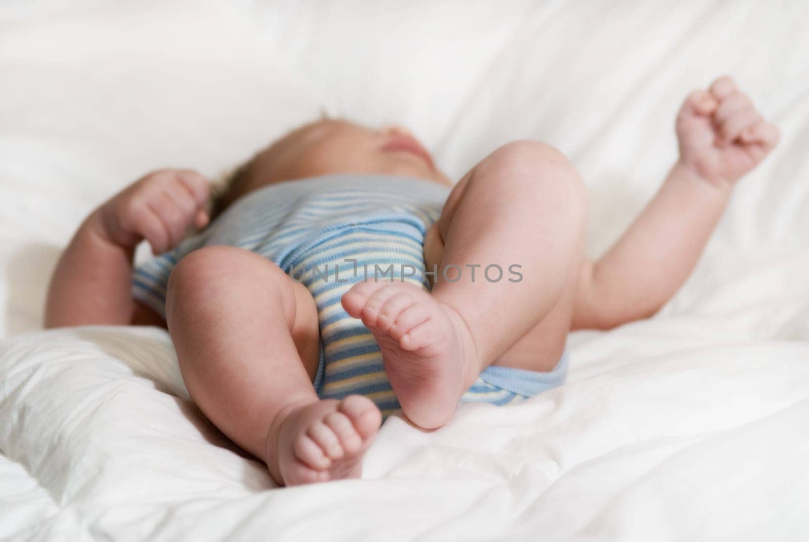 sleeping baby on a white blanket with feet