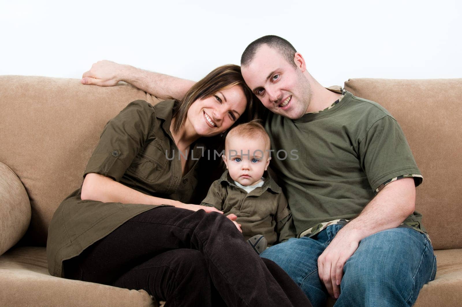 mom and dad on a sofa with their baby boy