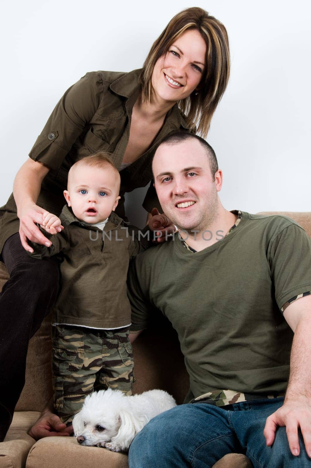 mom and dad on a sofa with their baby boy