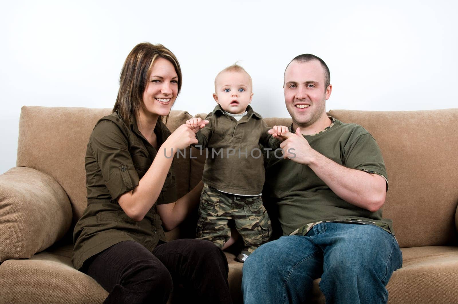 mom and dad on a sofa with their baby boy