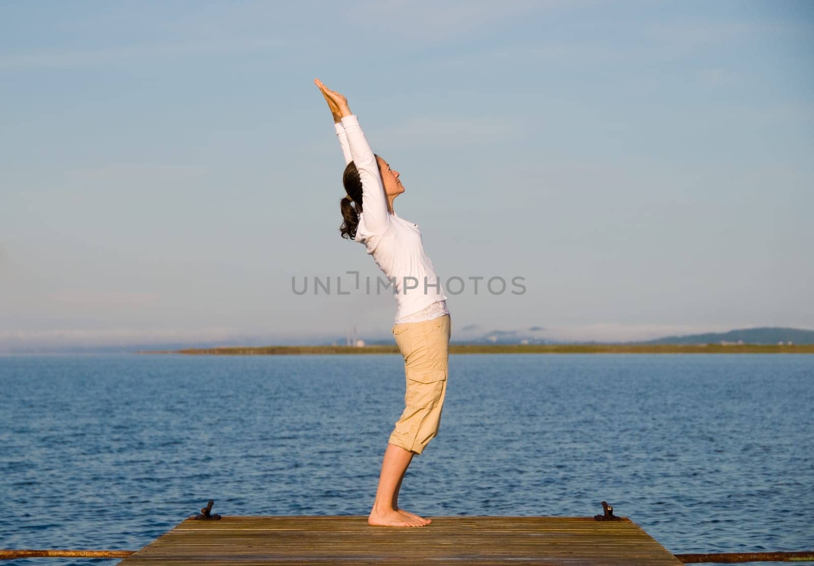 Yoga Woman on a dock by the ocean