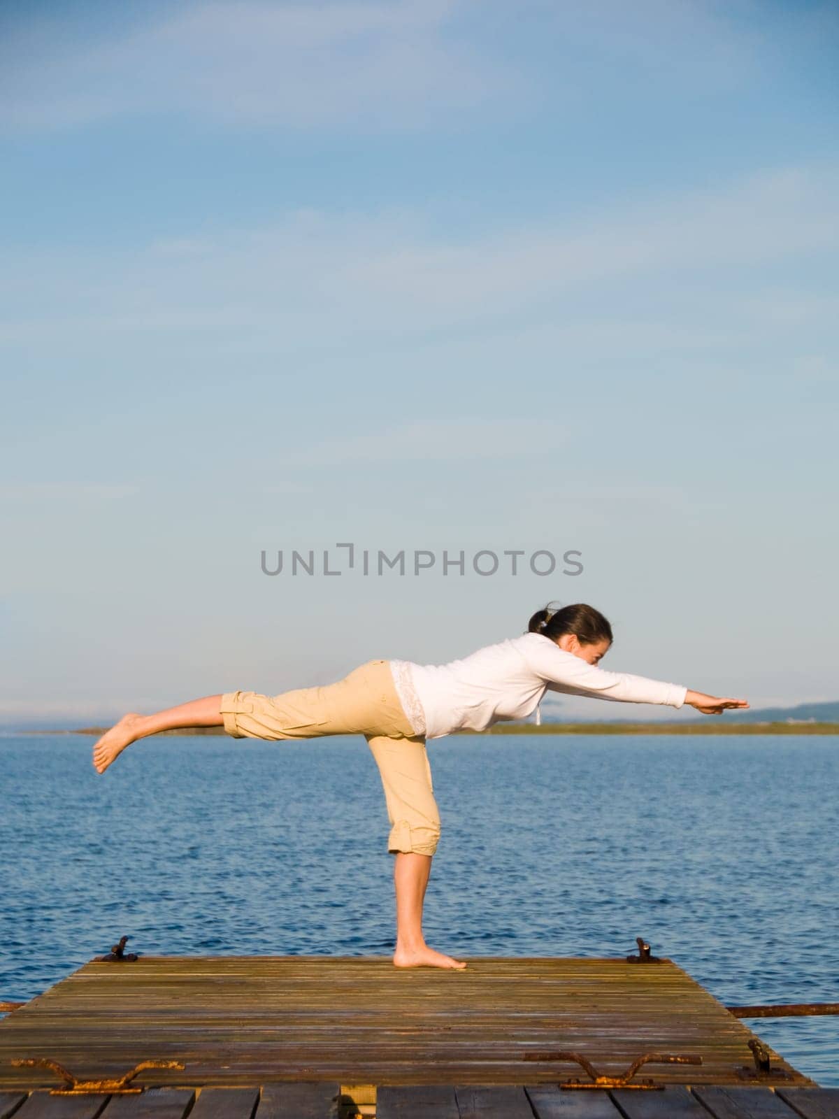 Yoga Woman on a dock by the ocean