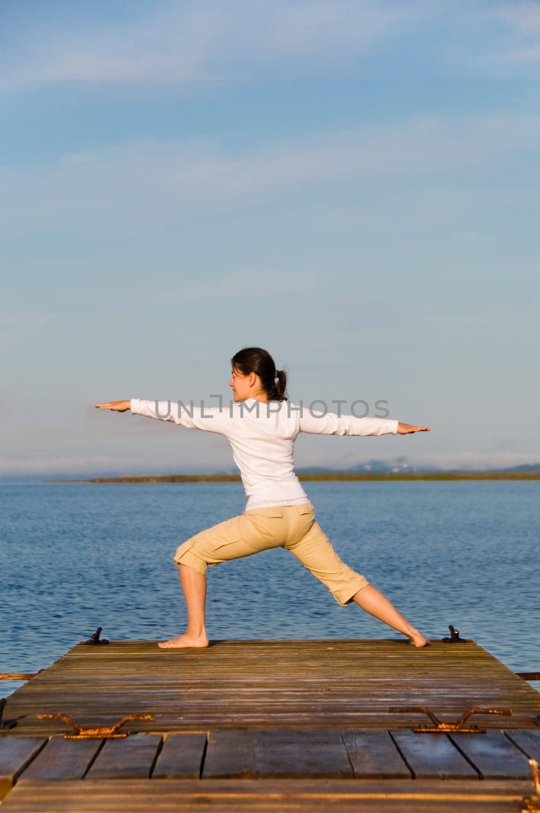 Yoga Woman on a dock by the ocean