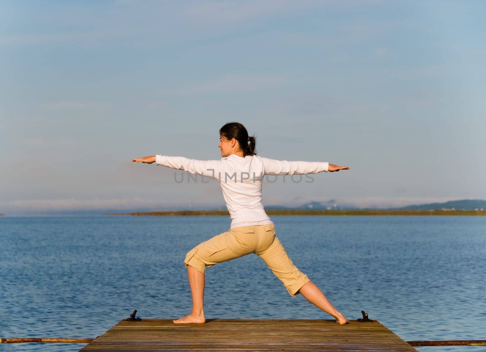 Yoga Woman on a dock by the ocean