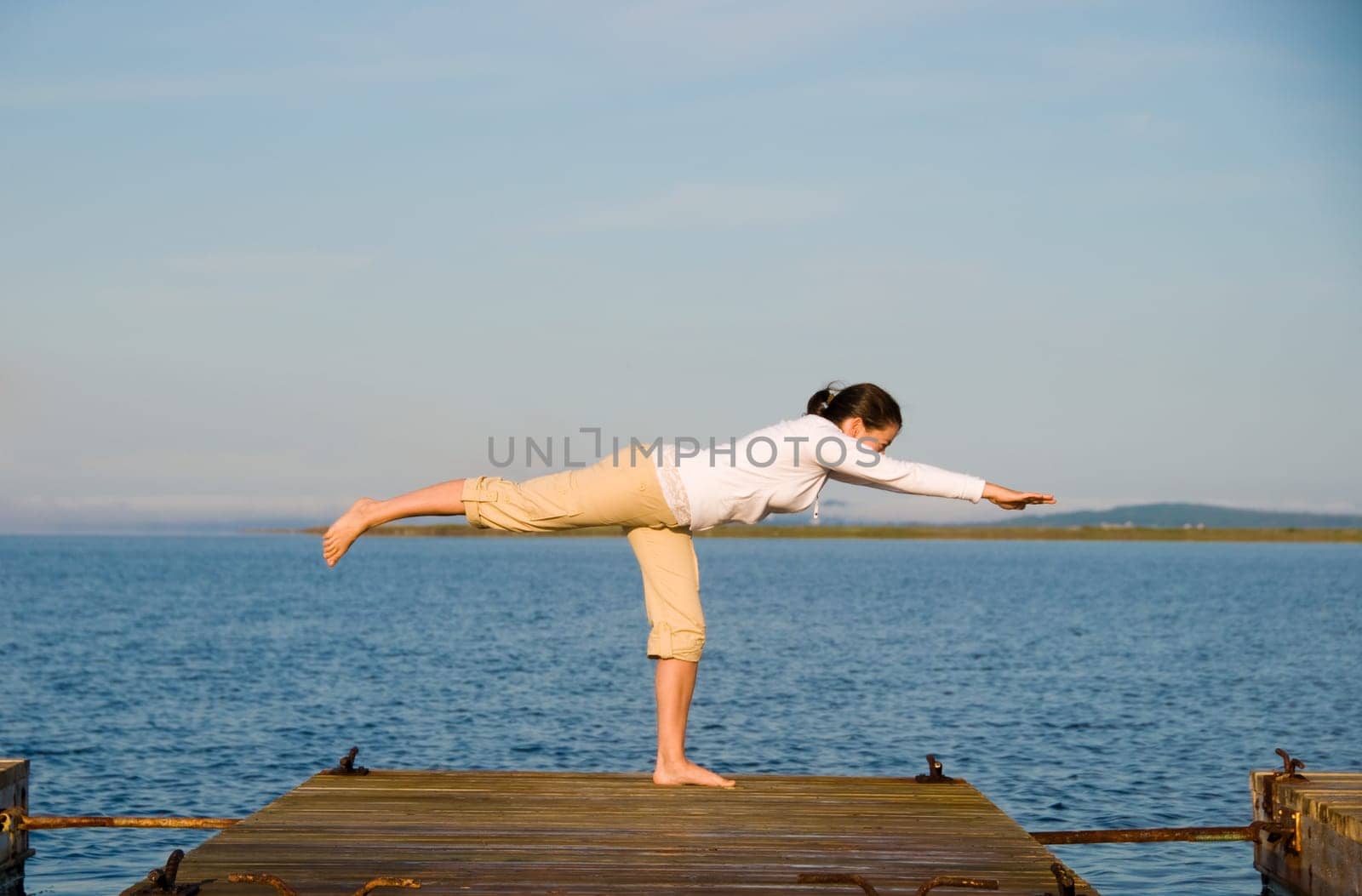 Yoga Woman on a dock by the ocean