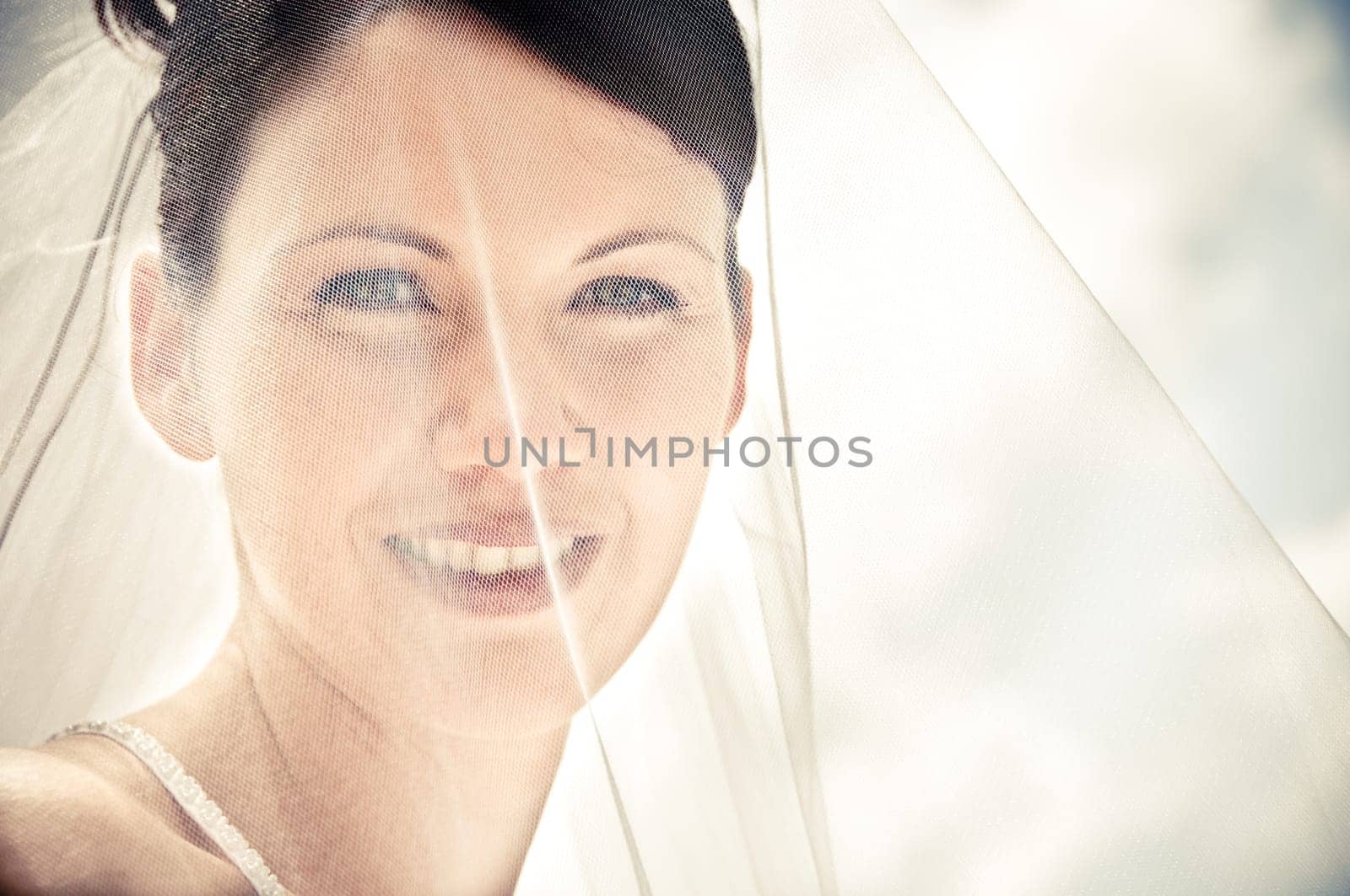 White Bride at her wedding posing with veil