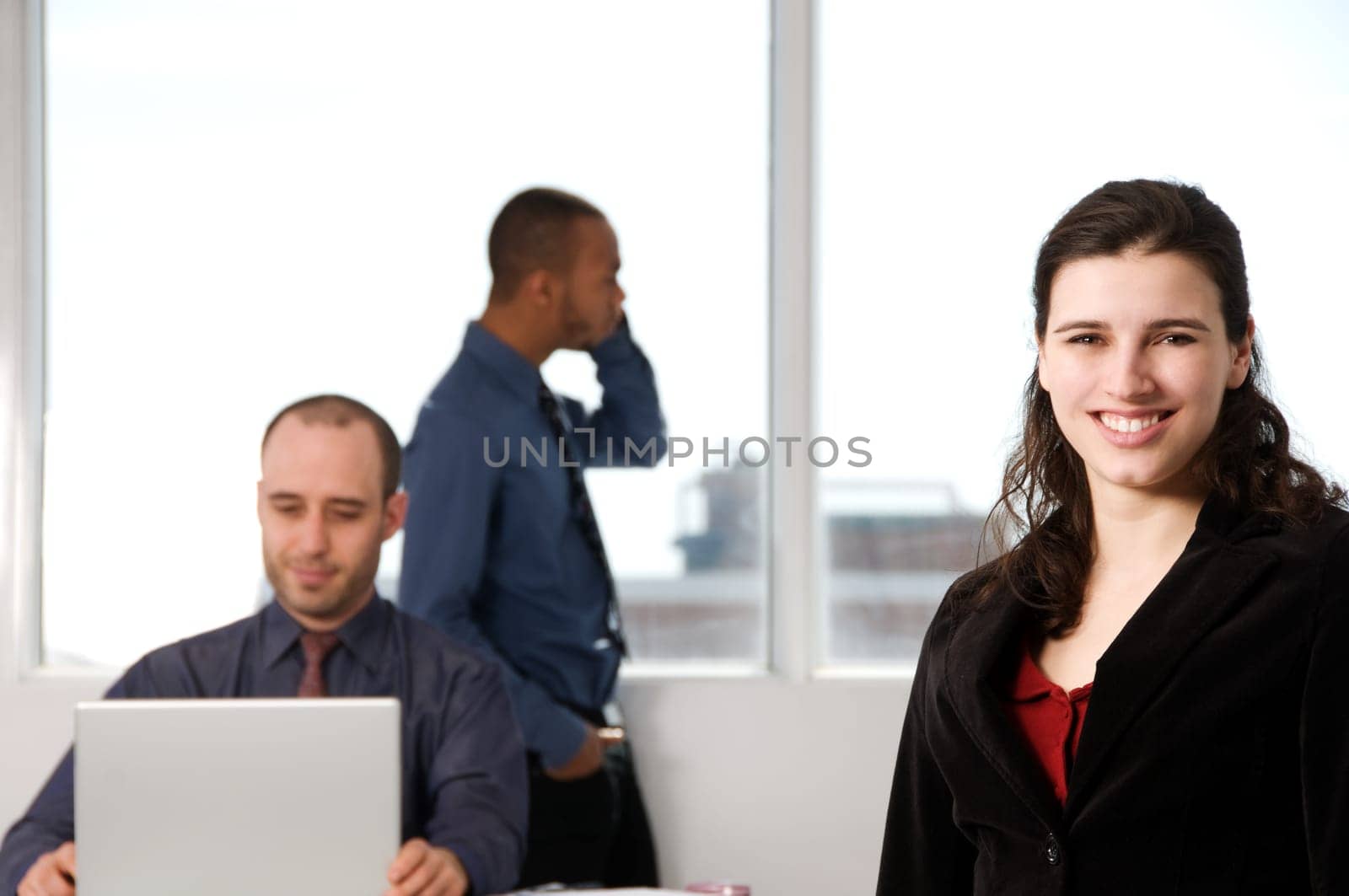 three business associates with a grey laptop