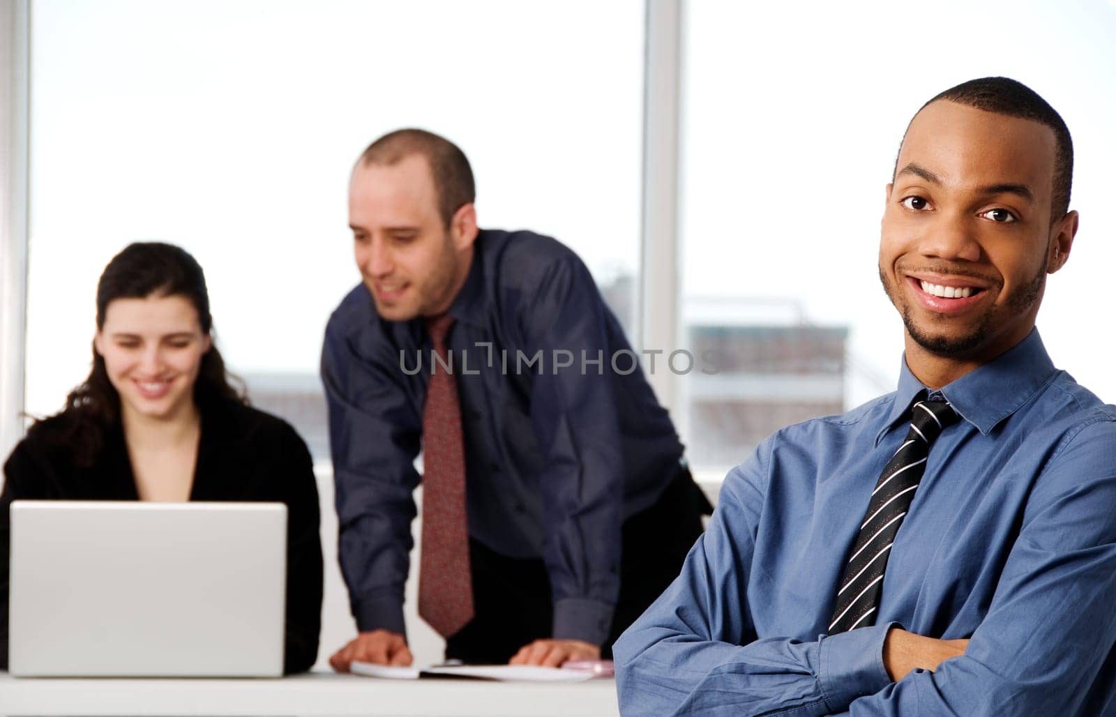 three business associates with a grey laptop