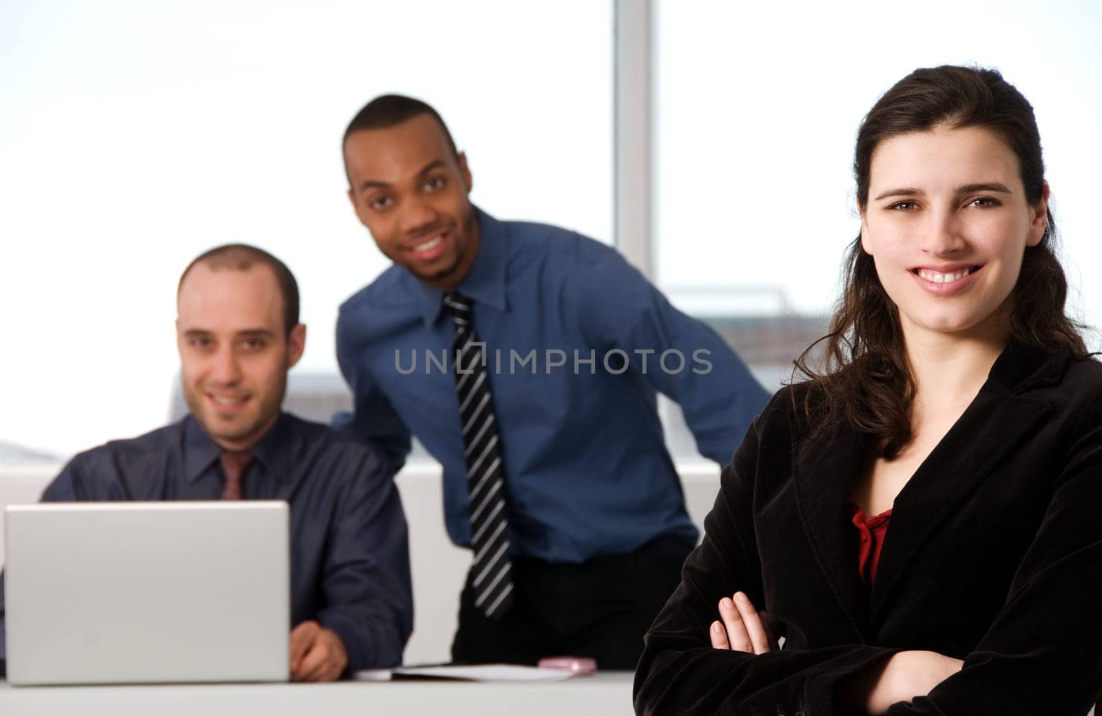 three business associates with a grey laptop