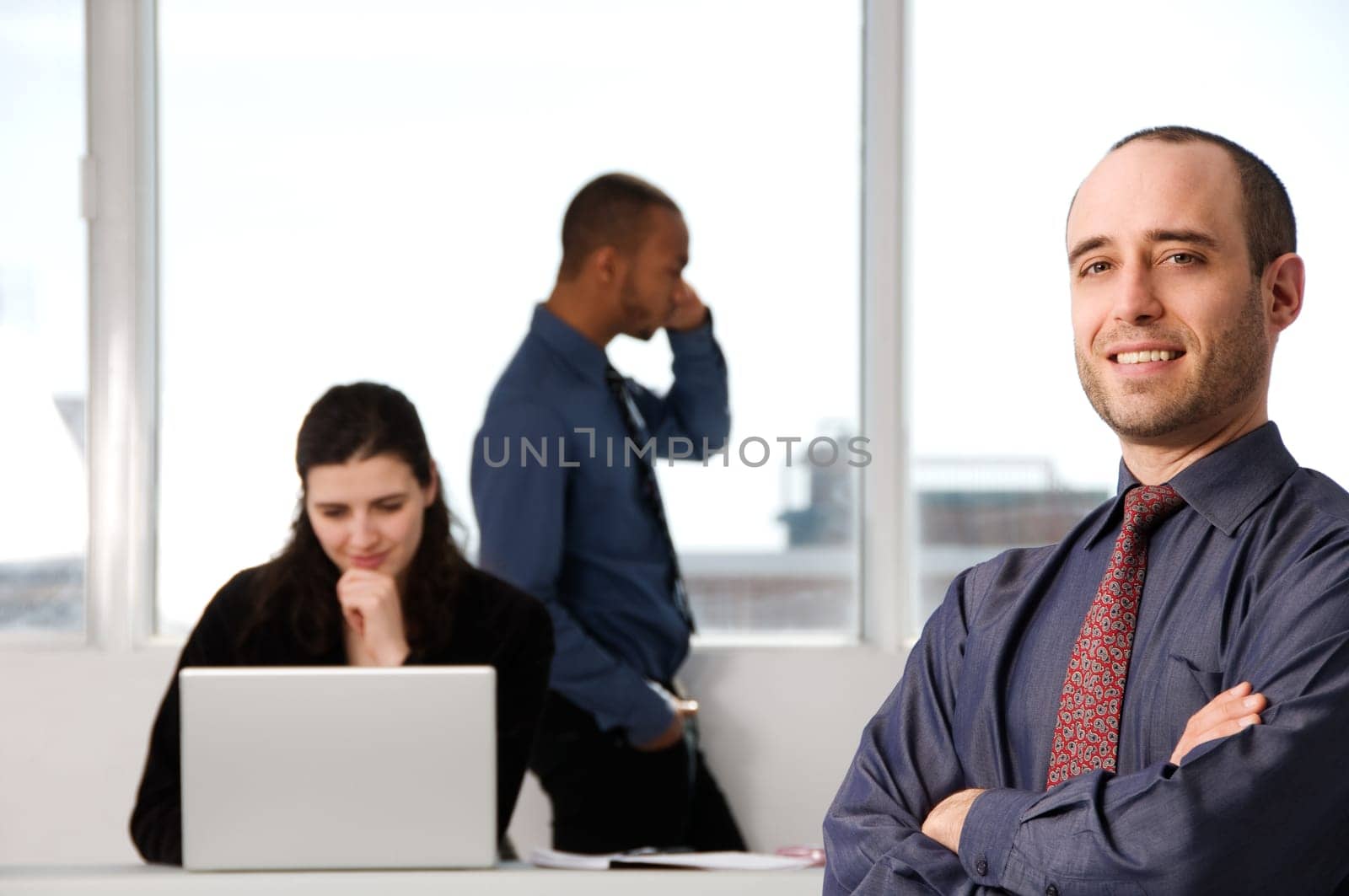 three business associates with a grey laptop