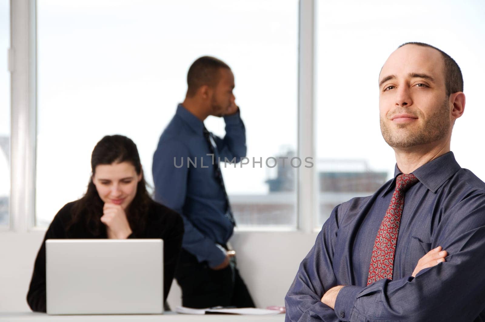 three business associates with a grey laptop