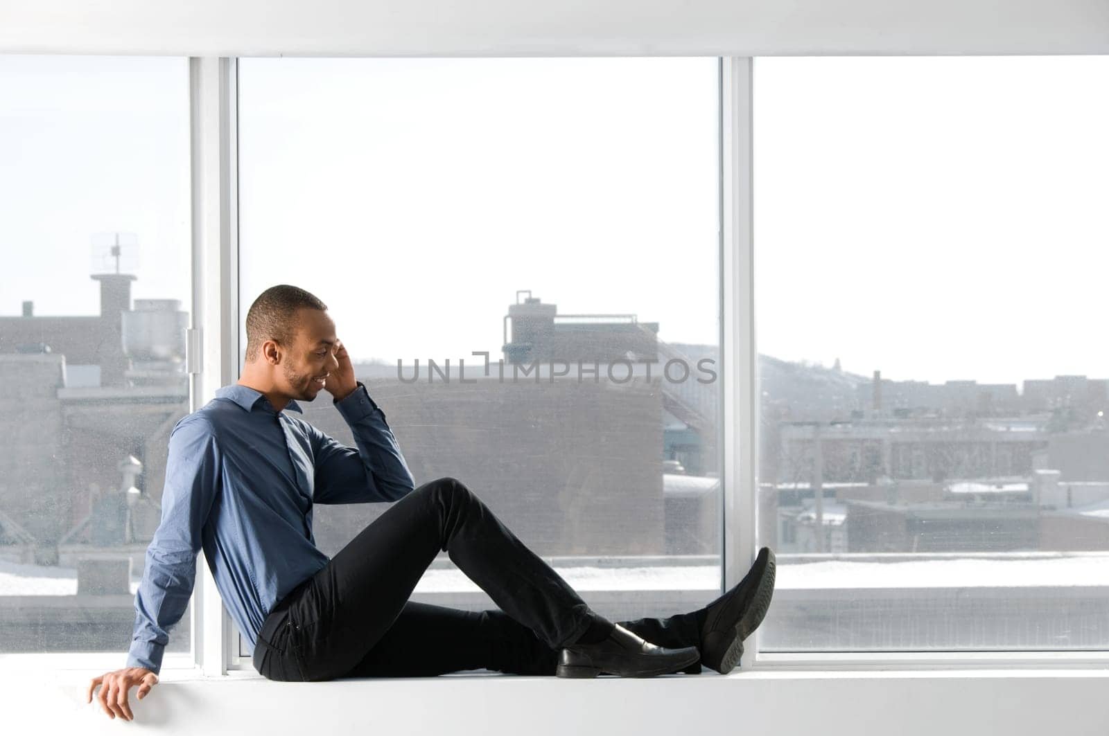 business man sitting on a window frame
