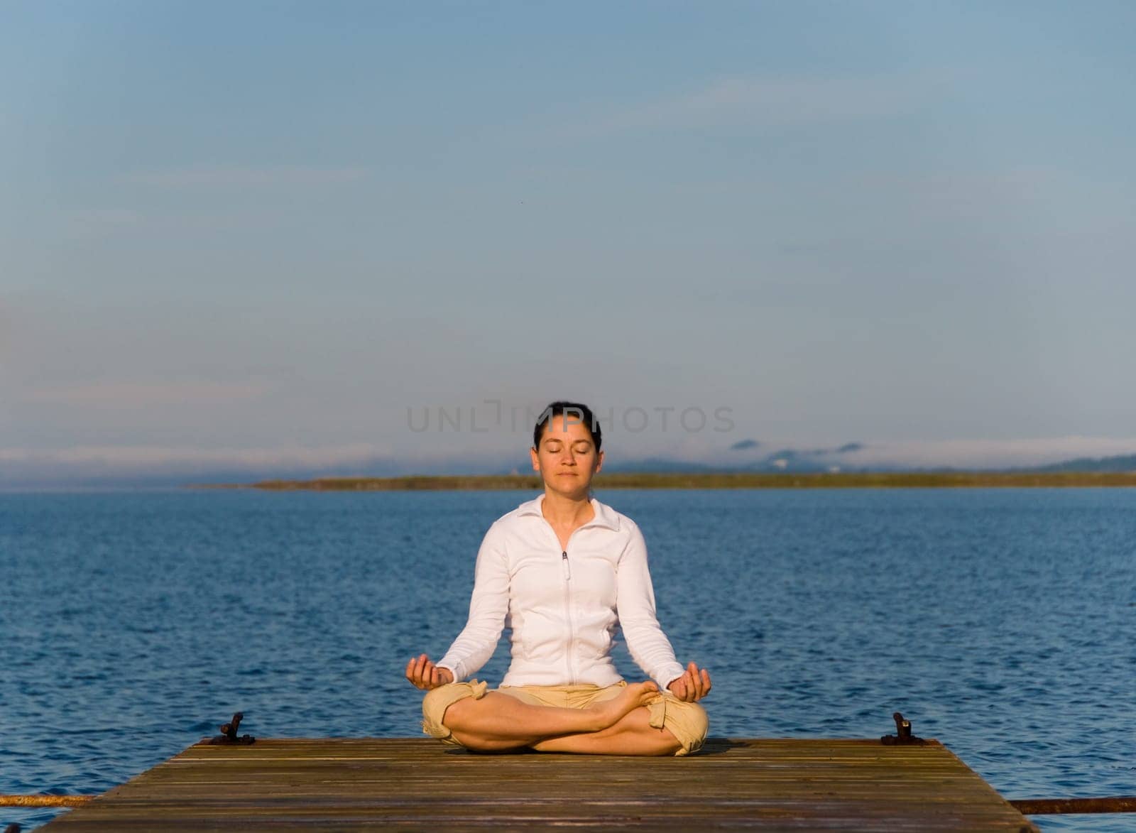 Yoga Woman on a dock by the ocean