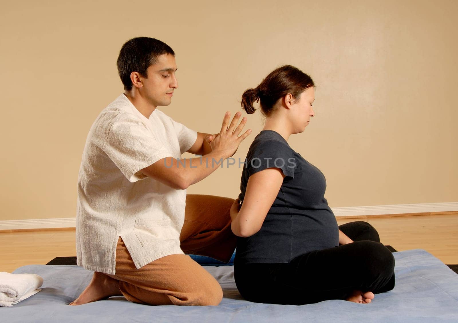 therapist giving thai massage to female client