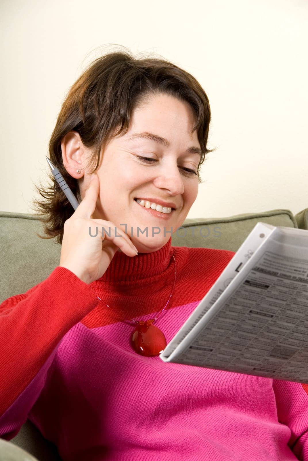 cute woman reading the newspaper on couch