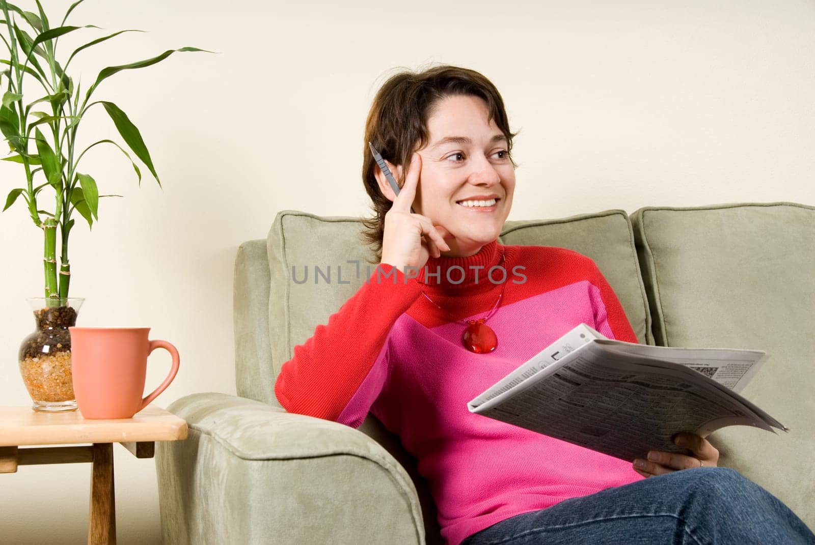 cute woman on couch looking at newspaper