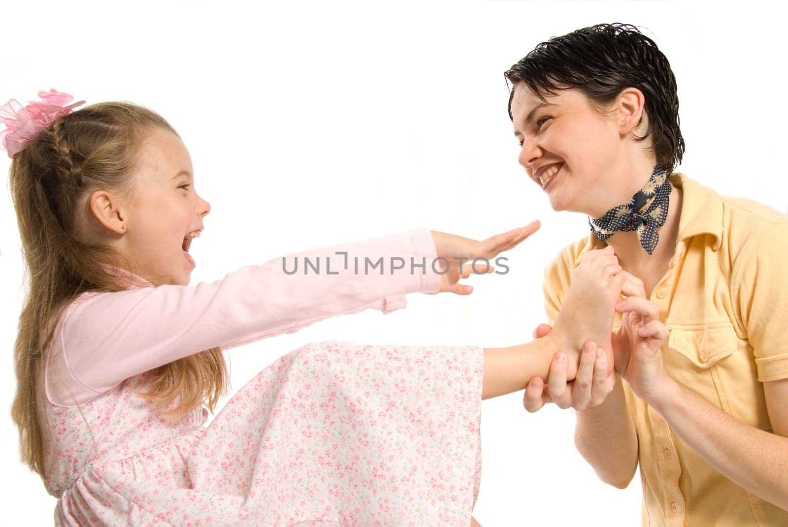 mom and daughter laughing whie tickling feet
