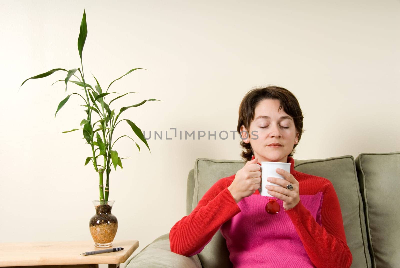 calm woman drinking from a white cup