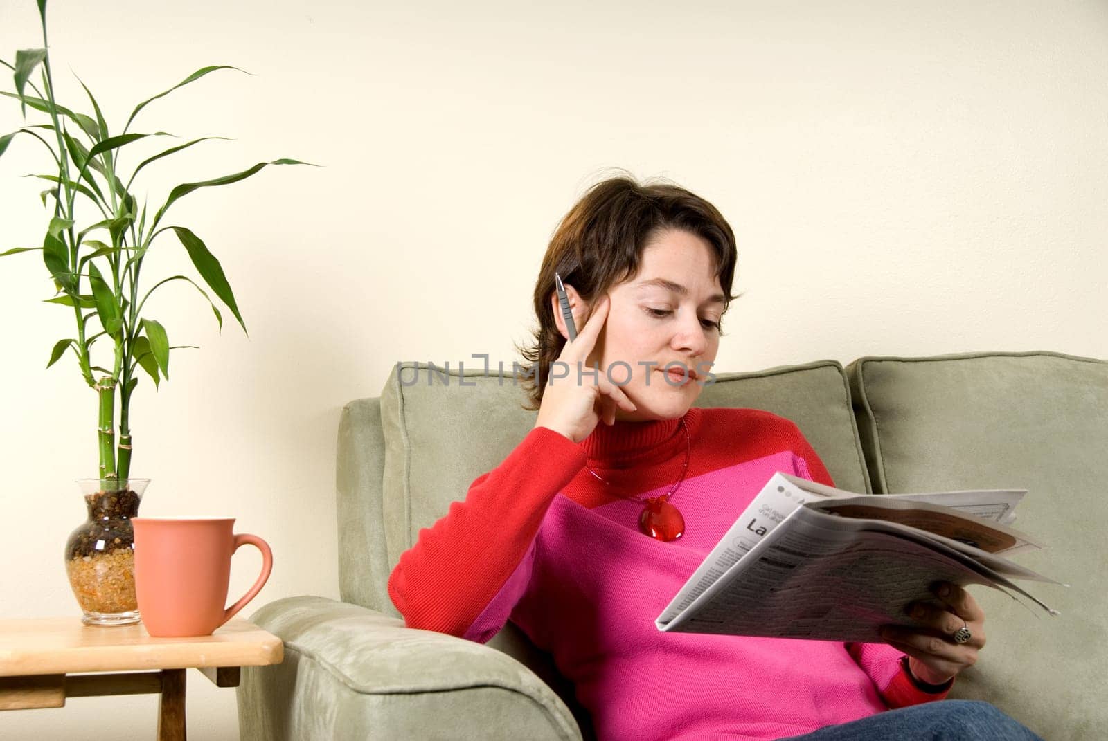 beautiful woman reading the newspaper on couch