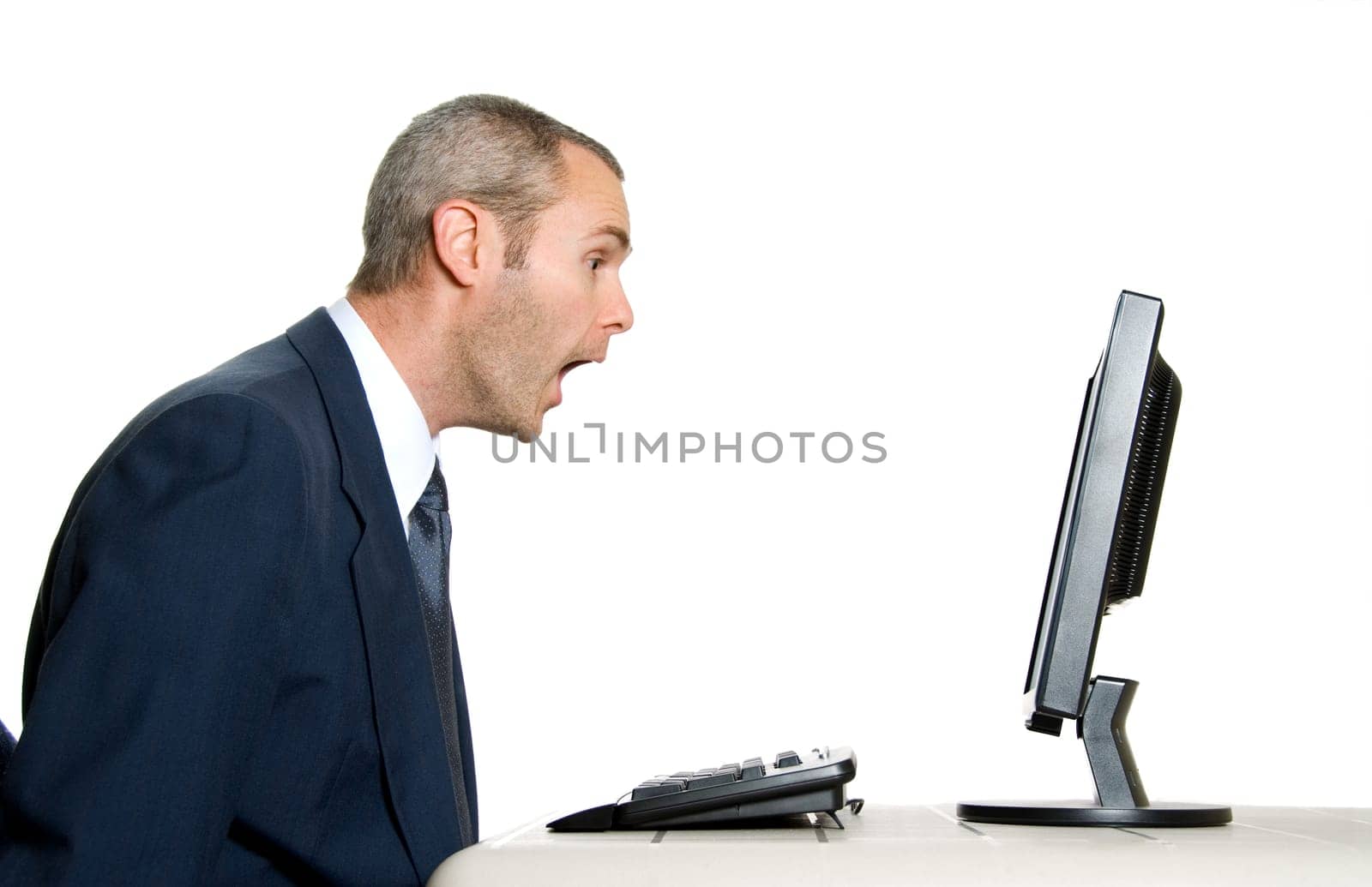 surprised man in blue suit in front of computer