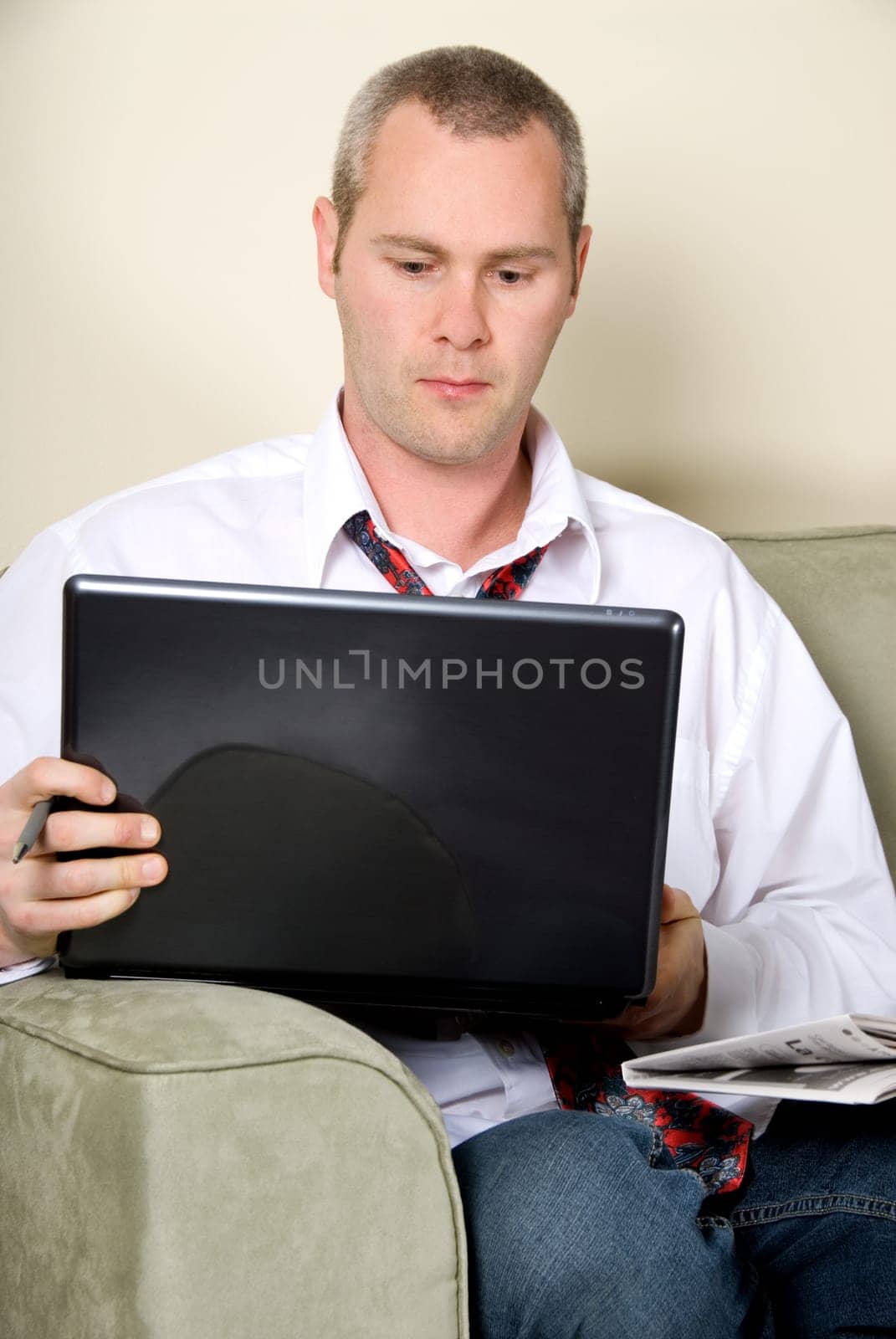 man reading the paper while surfing on the internet