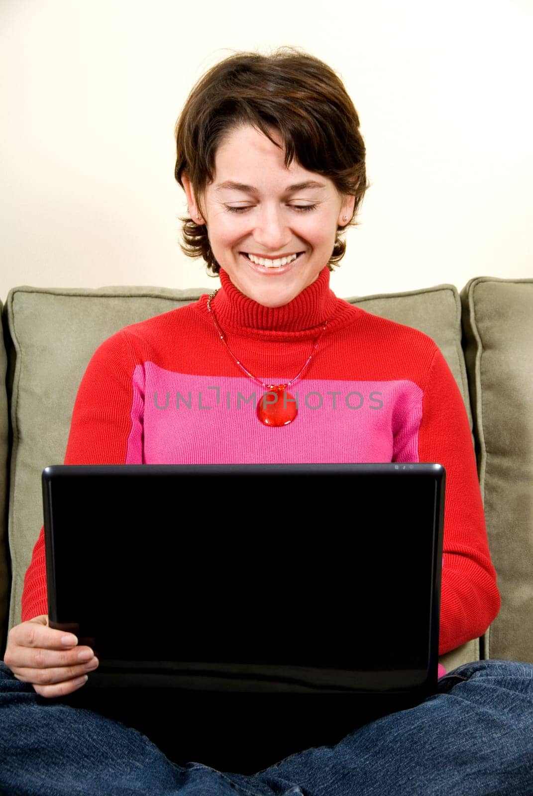 woman with laptop on the couch on her lap