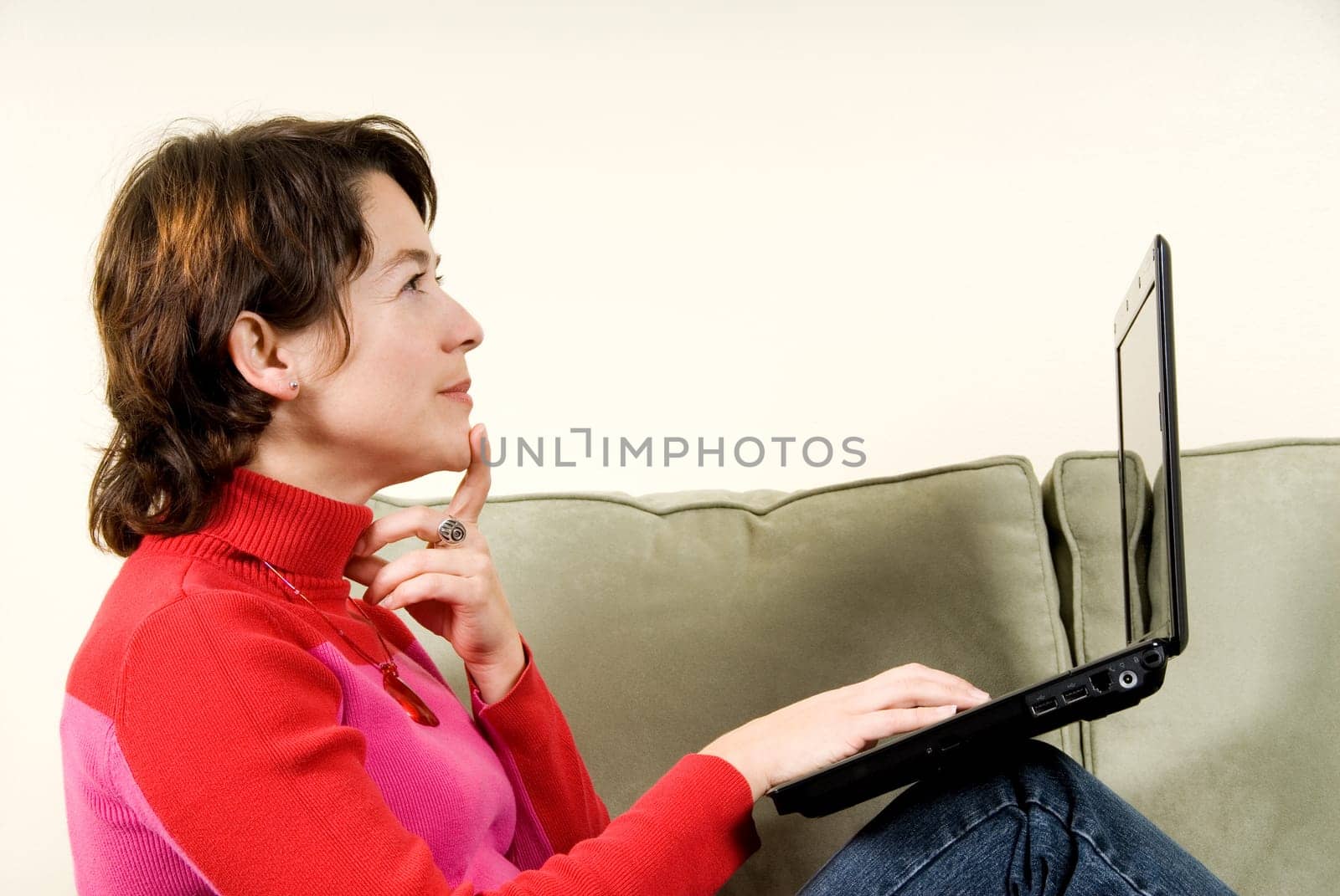 woman with balk laptop thinking on couch
