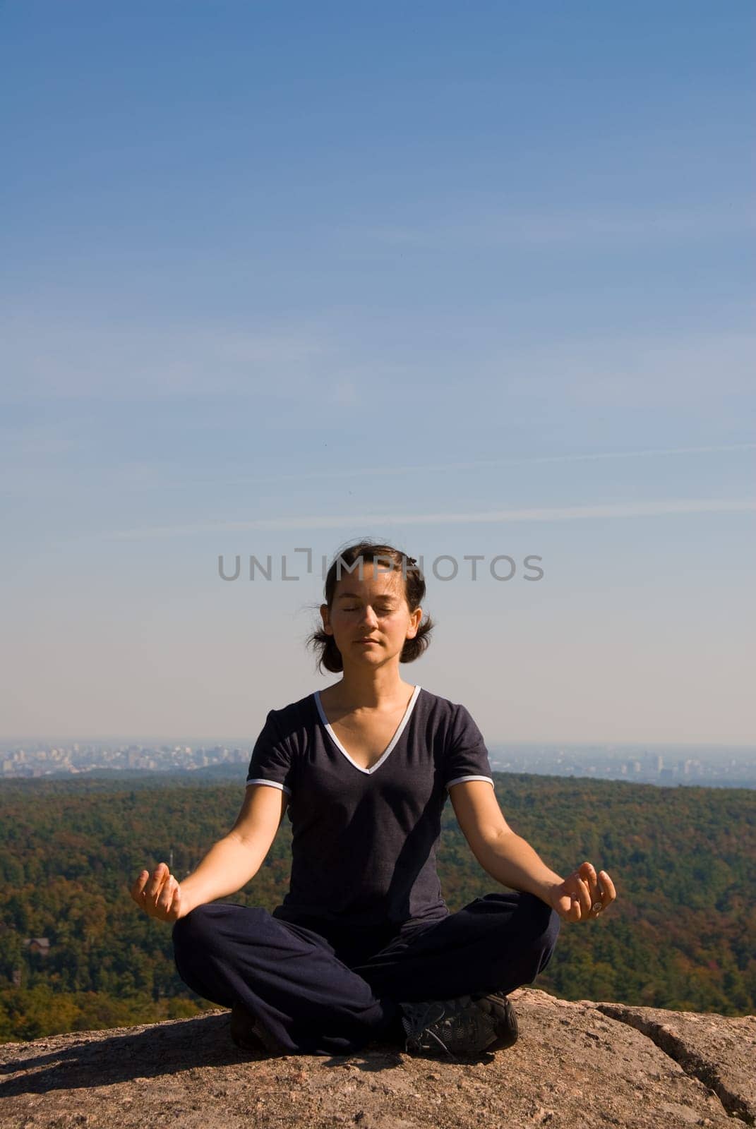 Woman on the top of a mountain meditating