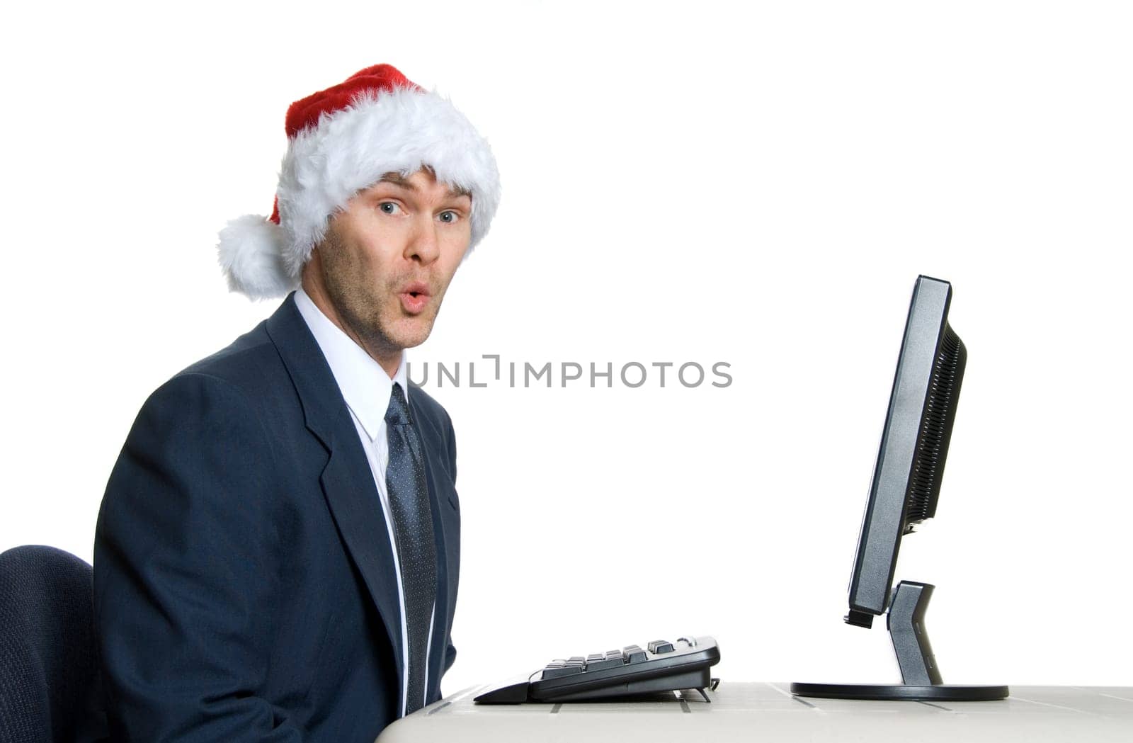 businessman in blue suit with a santa hat surprised