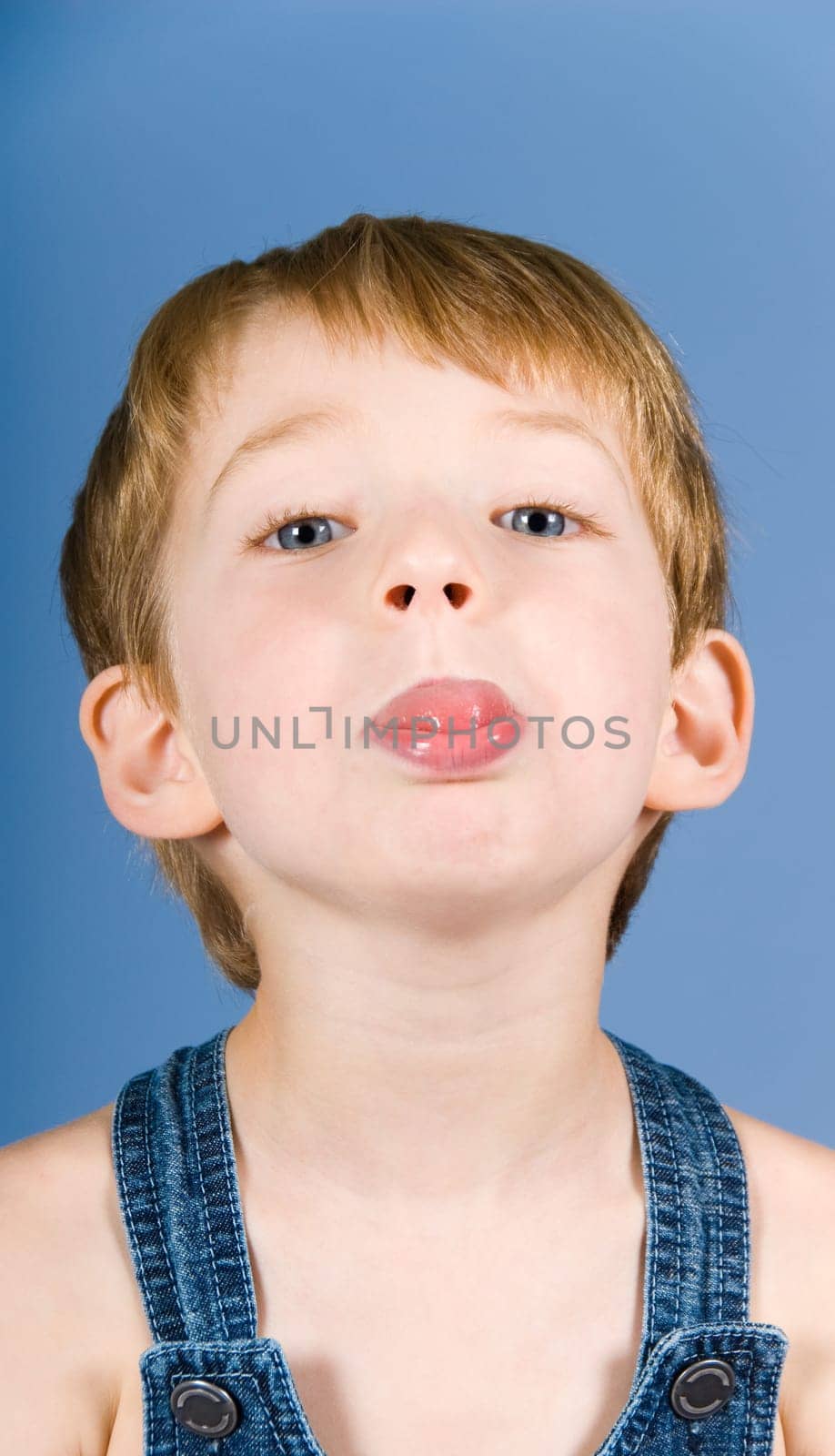 little boy doing a grimace in blue background
