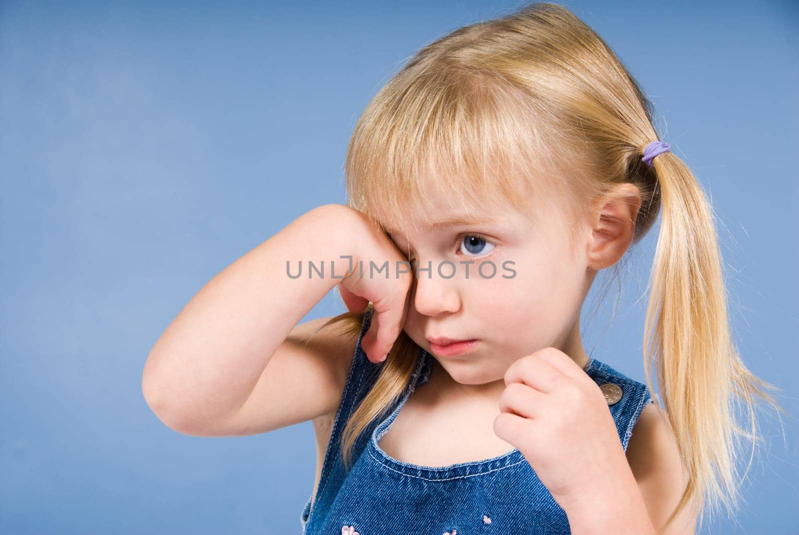 little cute blond girl on a blue wall