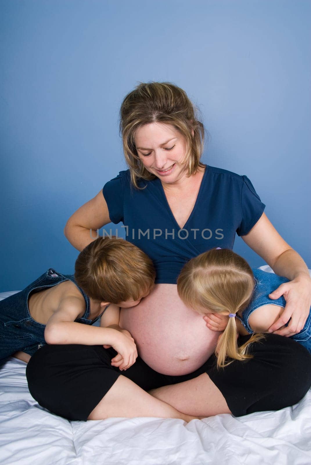 two cute kids with their pregnant mother