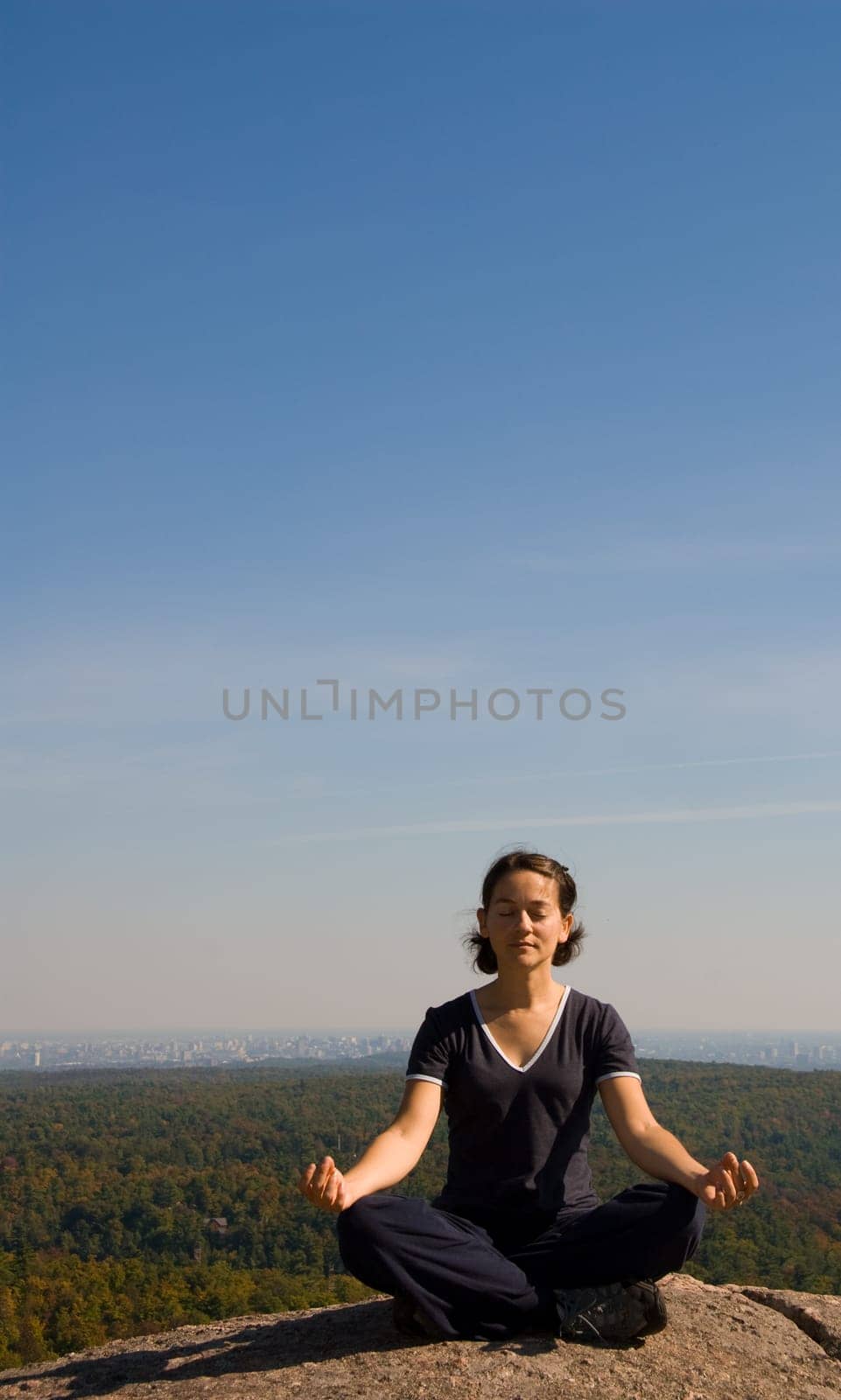 Woman on the top of a mountain meditating