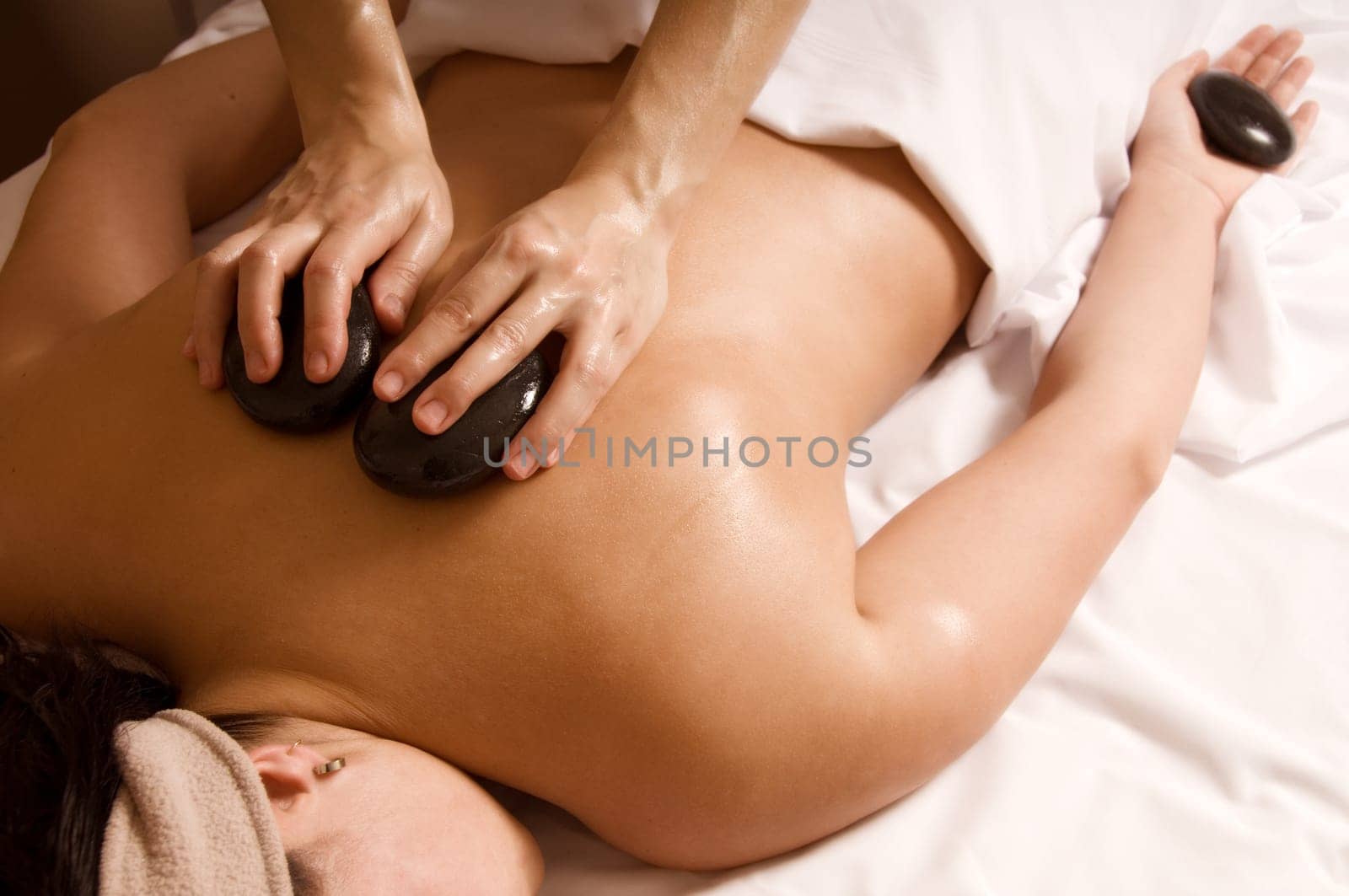 Therapist giving a hot stone massage to client