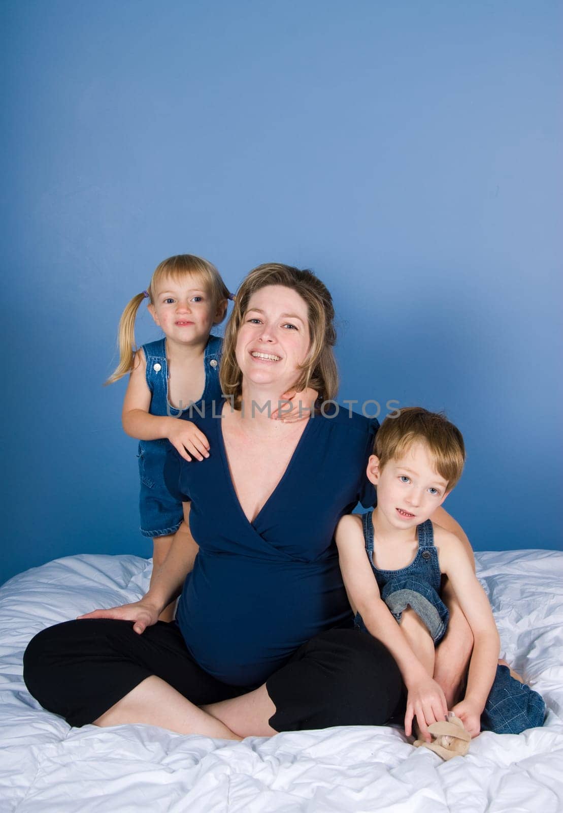 two cute kids with their pregnant mother